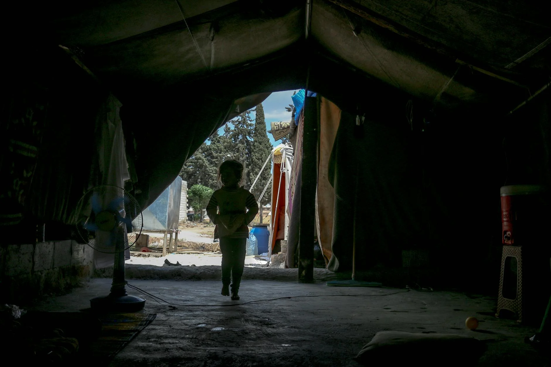 unrecognizable child walking in tent